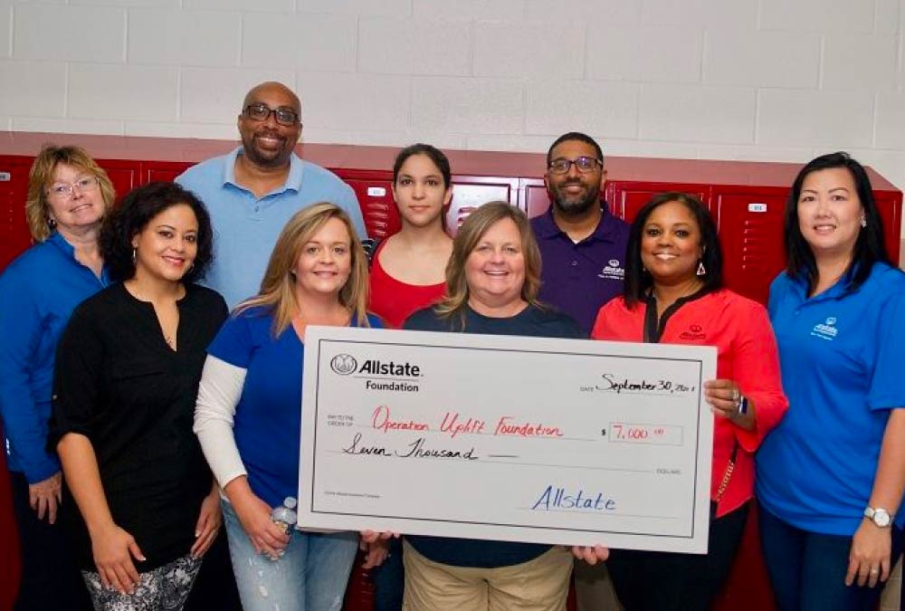 Marquel and Paul with team holding check they are donating to charity